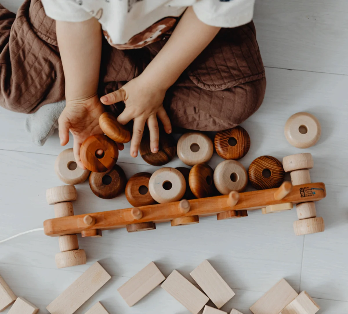 Young child playing with wooden toys