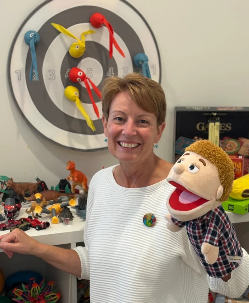 Marianne Doble, play therapist at Path2Potential, holding a hand puppet in her Noosaville therapy room